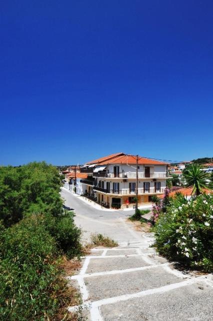 an empty road in a town with a building at Hotel Korakakis Beach in Finikounta