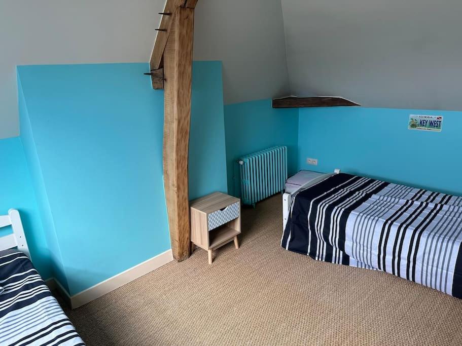 um quarto com uma cama e uma parede azul em Beauvais Maison bourgeoise centre-ville. em Beauvais
