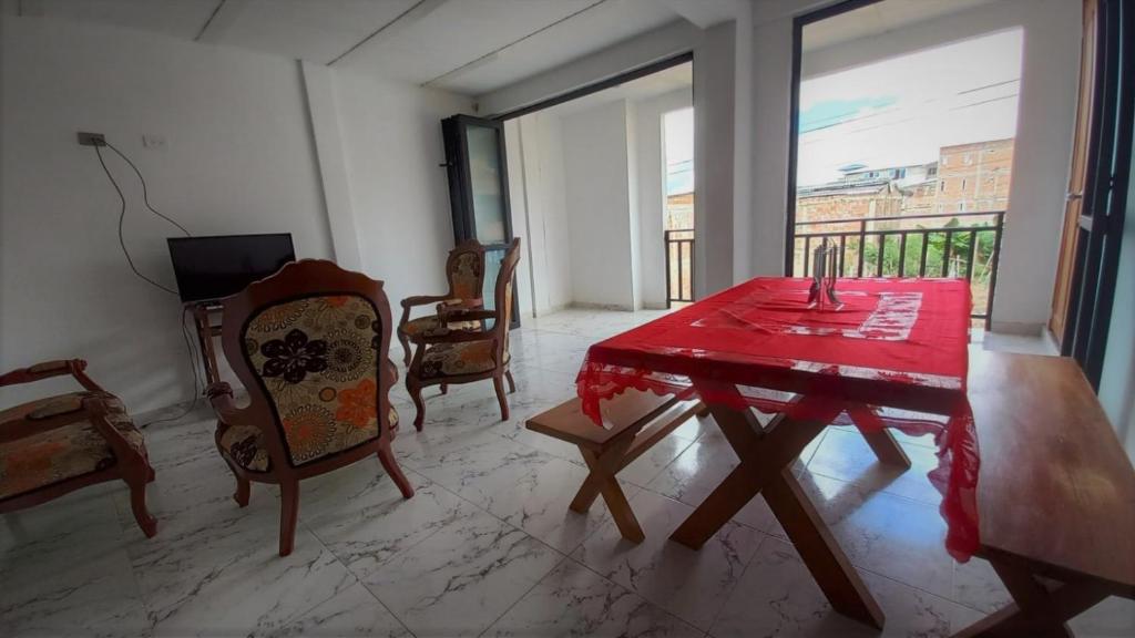 a dining room with a red table and chairs at Apartamento Jardín Colombiano in Calima