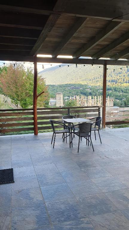 a table and chairs on a patio with a view at Villa Dabderr Mestia in Mestia
