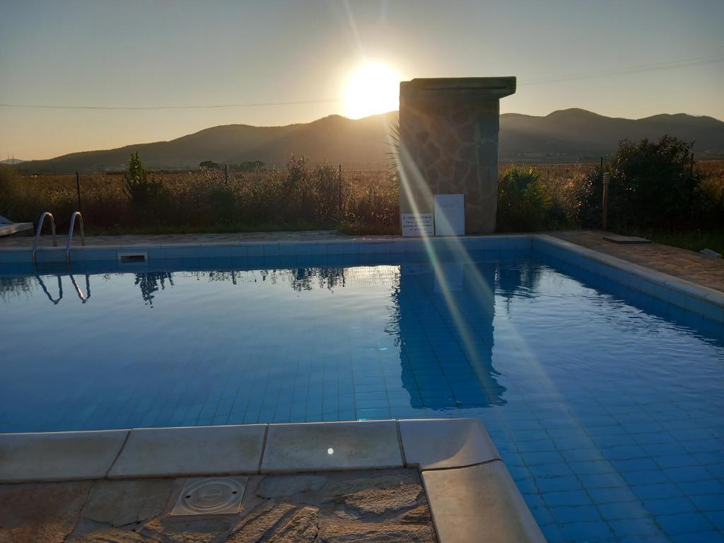 een zwembad met zonsondergang op de achtergrond bij Agriturismo la Martina in Macchiascandona