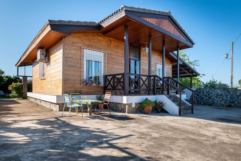 Una casa con una mesa y sillas delante de ella. en Casa de Madera del Turullote, en Écija
