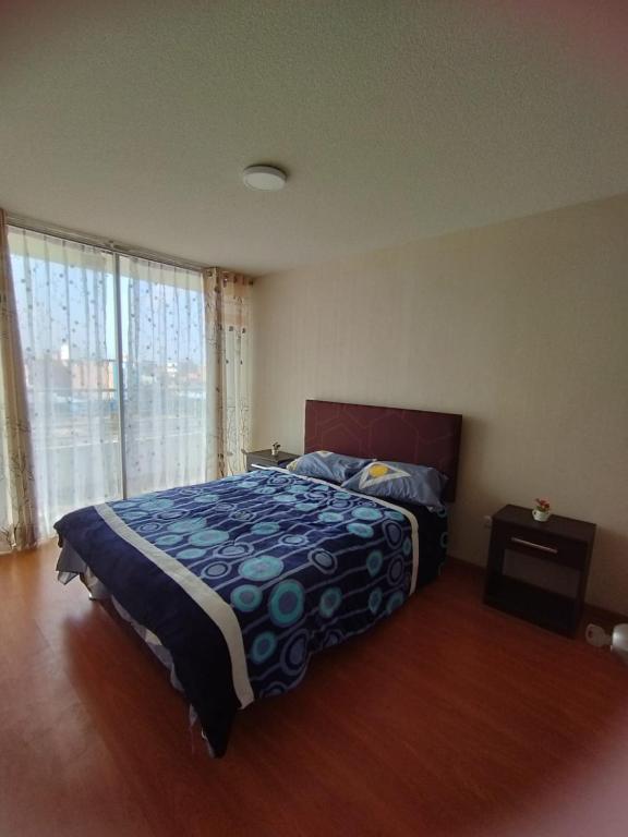 um quarto com uma cama e uma grande janela em Apartamento Fátima em Lima