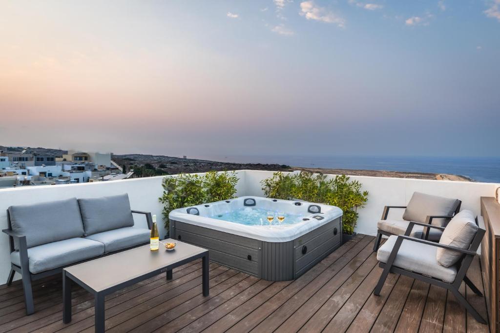 a hot tub on a deck with two chairs and a table at Private Penthouse with Heated Spa Bath Pembroke St Julians in Pembroke