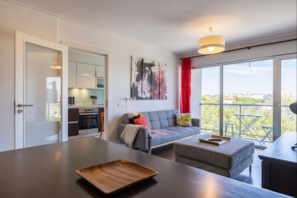 uma sala de estar com uma mesa e um sofá em Lovely 1 BDR Apartment With Pool by LovelyStay em Lisboa