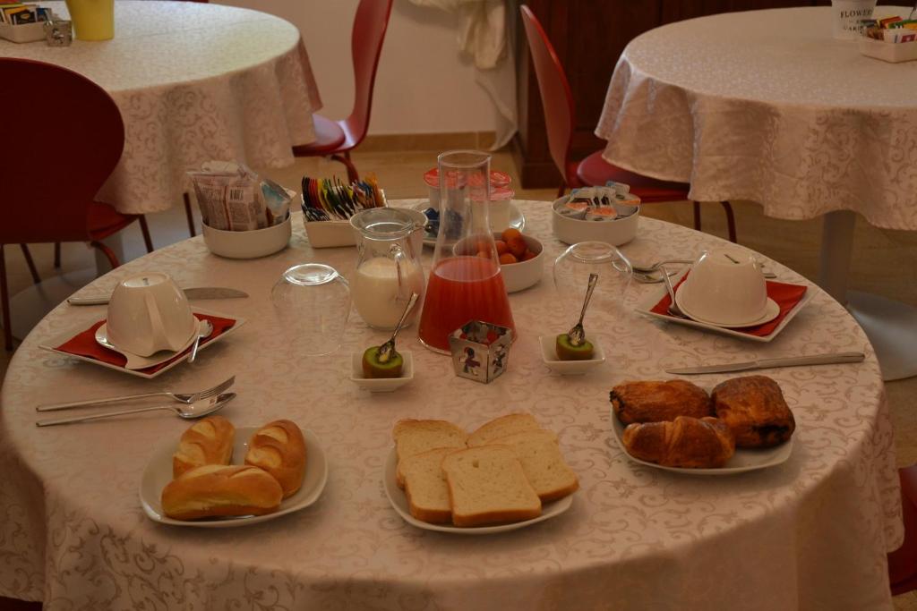 a table with plates of bread and pastries on it at B&B Torre Porta Marina in Ventimiglia