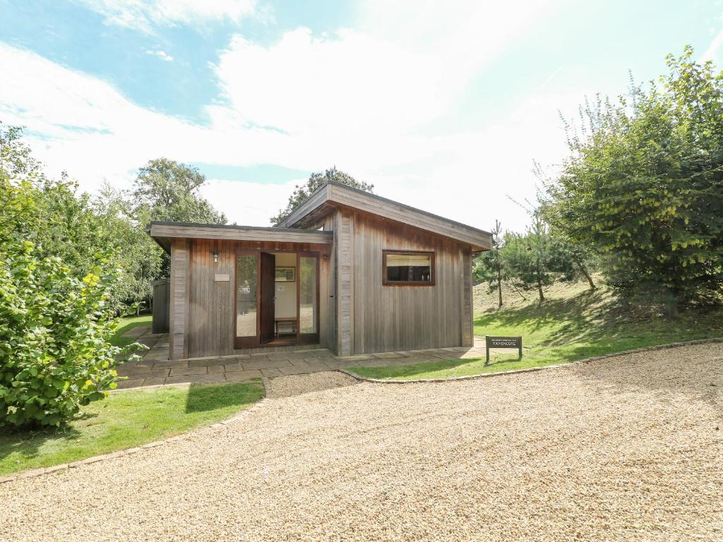 a small wooden house with a gravel driveway at Tickencote in Cottesmore