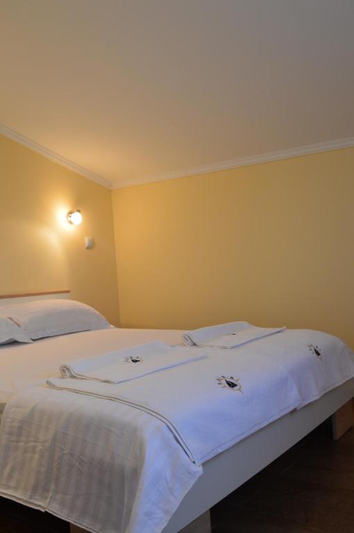 a bedroom with two beds with white sheets at APARTMANI SABB in Jezera