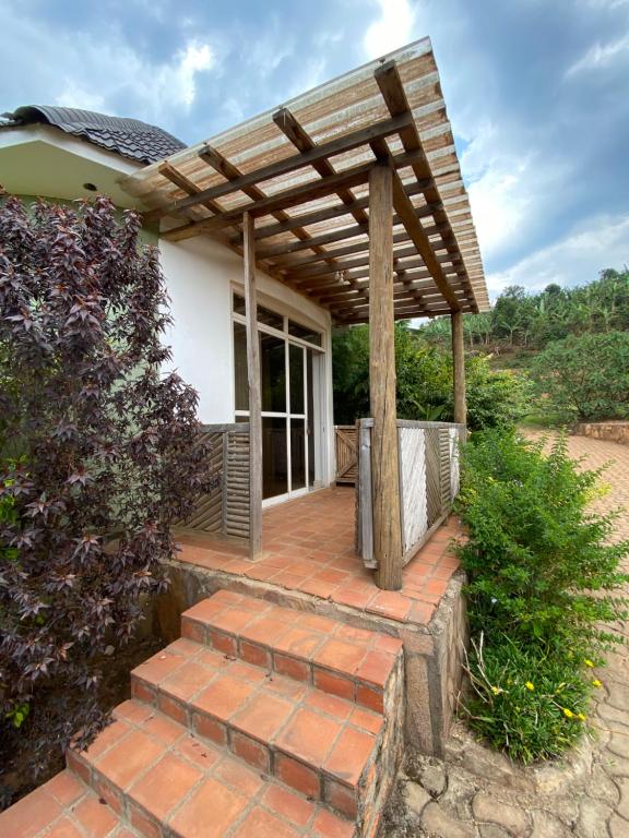 una pérgola de madera en una casa con escaleras en Rafiki Safari Lodge Bwindi en Kinkizi