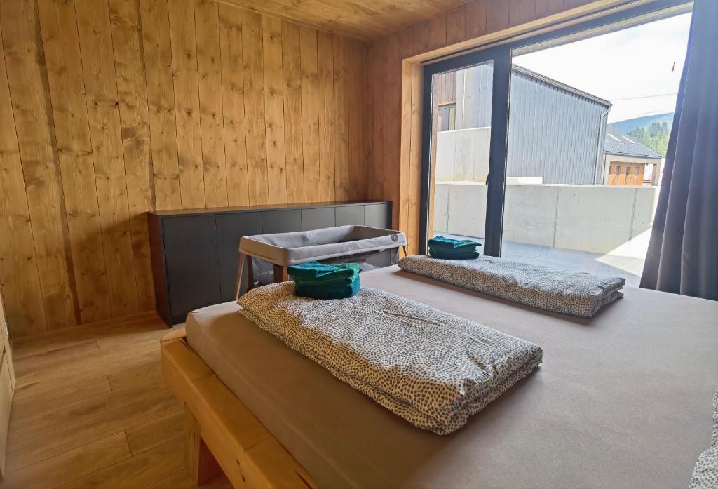 two beds in a room with a large window at Chalet Smreky in Telgárt