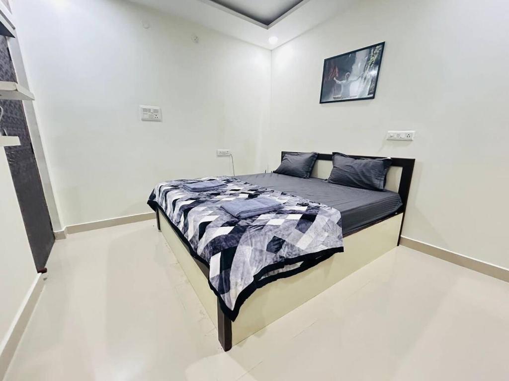 a bedroom with a bed in a white room at Bigson Service Apartments Gachibowli in Hyderabad