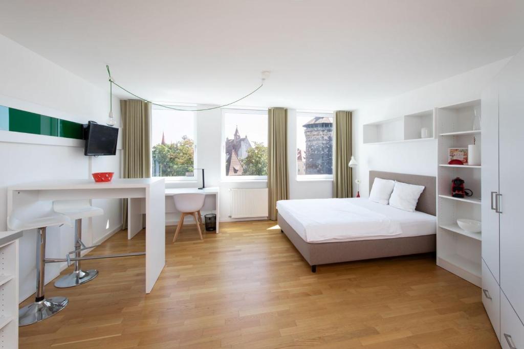 a bedroom with a bed and a desk and a desk at Brera Serviced Apartments Nürnberg in Nuremberg