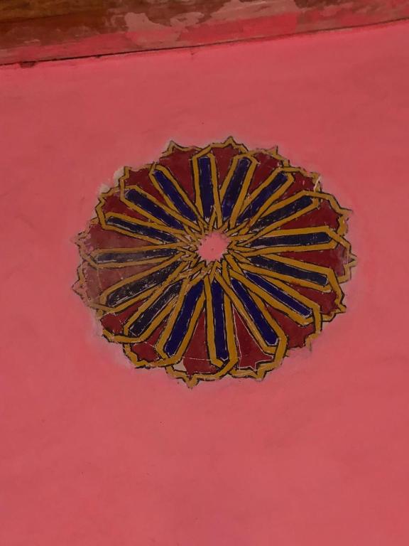 a painting of a circle on a pink wall at Gite Ifoulou Tassaout in Ifoulou