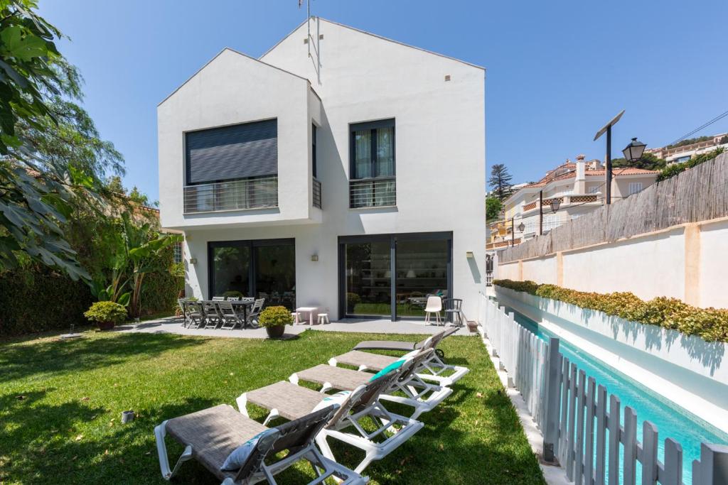 uma casa com piscina e espreguiçadeiras em Villa Pedregalejo near the beach em Málaga