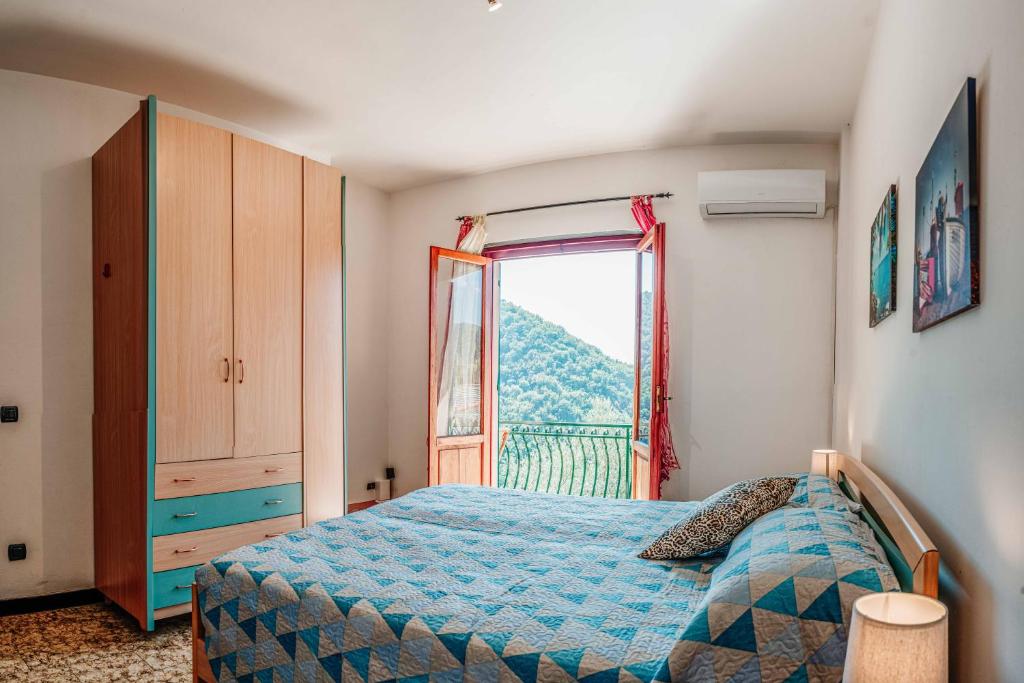 een slaapkamer met een blauw bed en een raam bij Turri House--- WiFi -Garden-Parking -Balcony in Recco