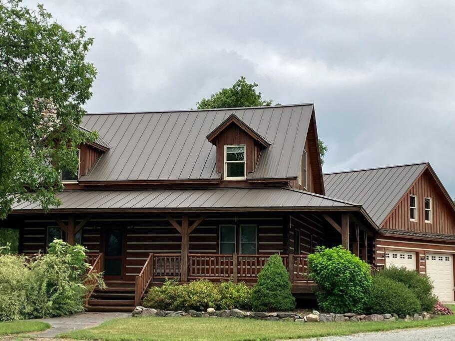a large wooden house with a gambrel roof at Cozy Oaks Cabin 