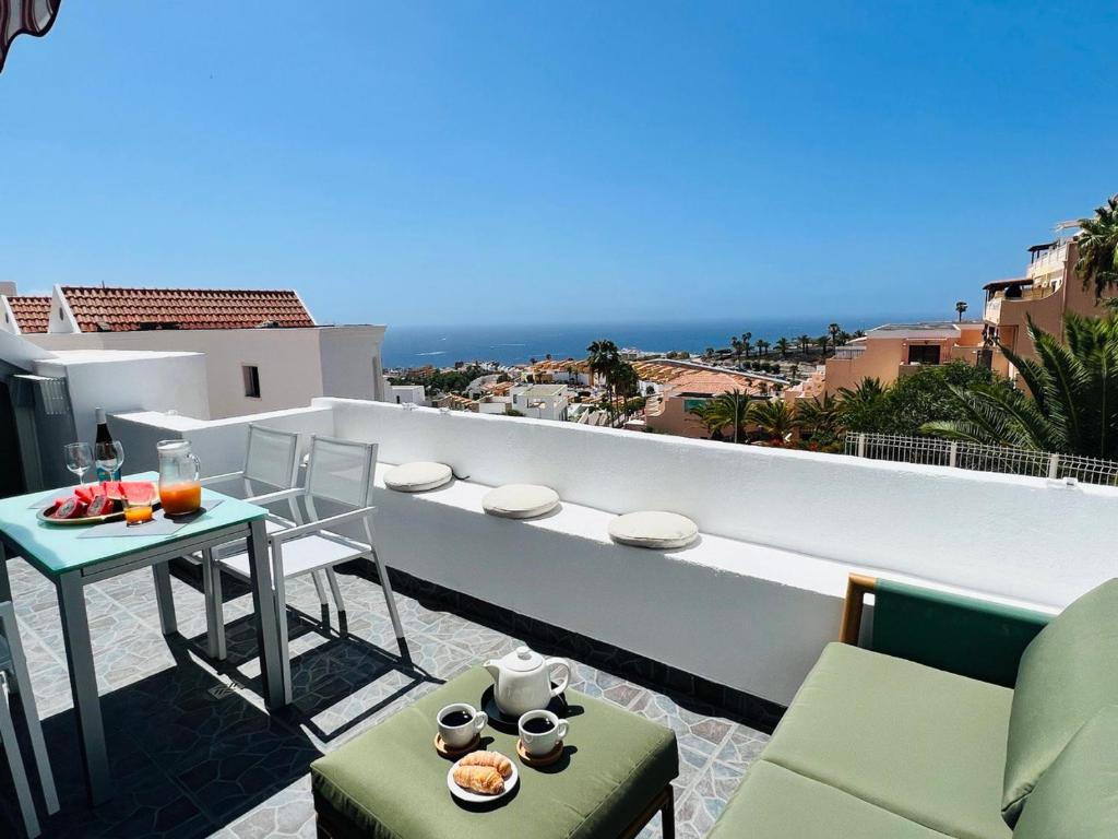 アデへにあるPaulMarie Duplex Ocean Viewのテーブルと椅子と海のあるバルコニー