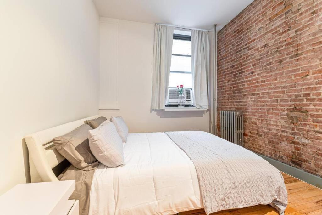 sypialnia z ceglaną ścianą i łóżkiem w obiekcie 4BR in the heart of Tribeca w Nowym Jorku