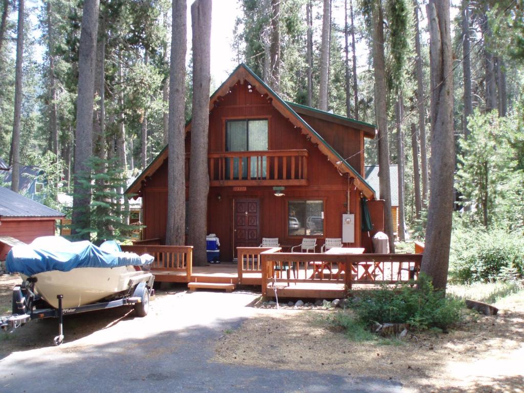 a log cabin in the woods with a table and a boat at 2 bedroom, 2 bath, sleeps 6 adults West End of Donner Lake DLR#021 in Truckee