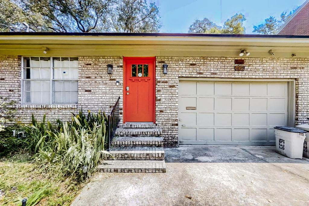 a brick house with a red door and a garage at Mystic Moon Hideaway in Jacksonville