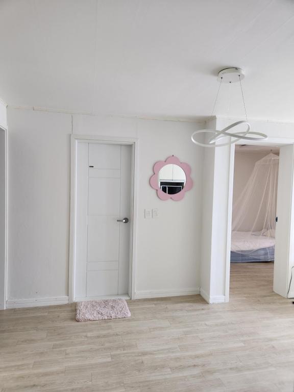 ein weißes Zimmer mit einer Tür und einem Schlafzimmer in der Unterkunft Urbanspace Pohang in Pohang
