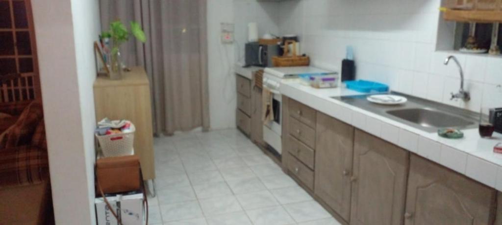 une cuisine avec un évier et un plan de travail dans l'établissement White appartment, à Flic-en-Flac