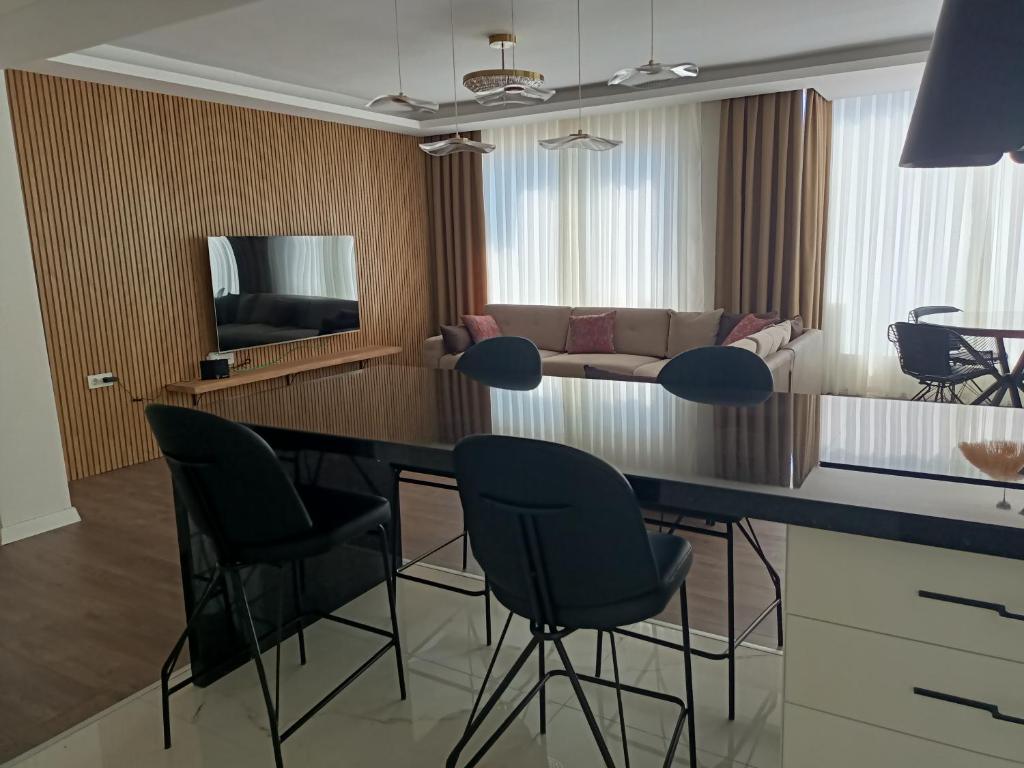 a living room with a bar with chairs and a couch at Stylish Flat in the Central Area in Alanya