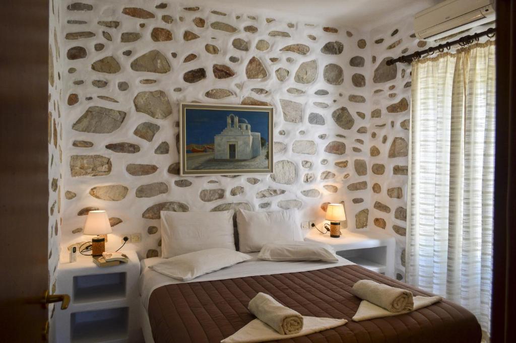a bedroom with a stone wall with a bed at Villa Peristeri in Agios Georgios