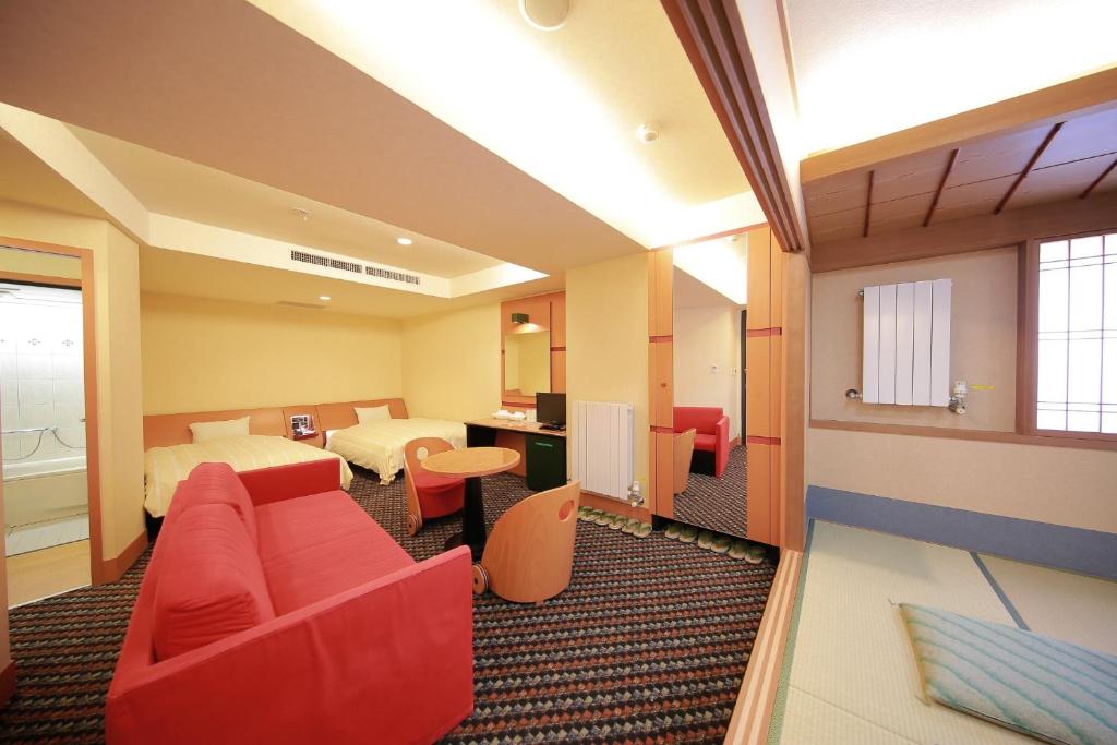 ein Hotelzimmer mit einem roten Sofa und einem Bett in der Unterkunft Hashima - Hotel - Vacation STAY 52815v in Hashima