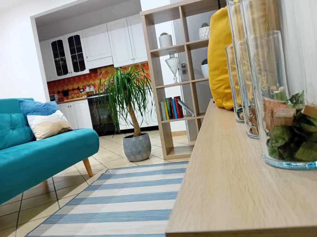 uma sala de estar com uma mesa e um sofá azul em Casa vacanza Argo. Bovo marina/torre salsa em Montallegro