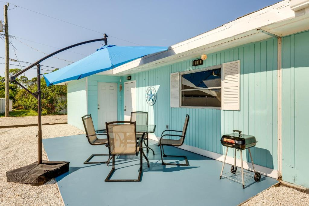 a patio with a table and chairs and an umbrella at Pet-Friendly Venice Vacation Rental, 3 Mi to Beach in Venice
