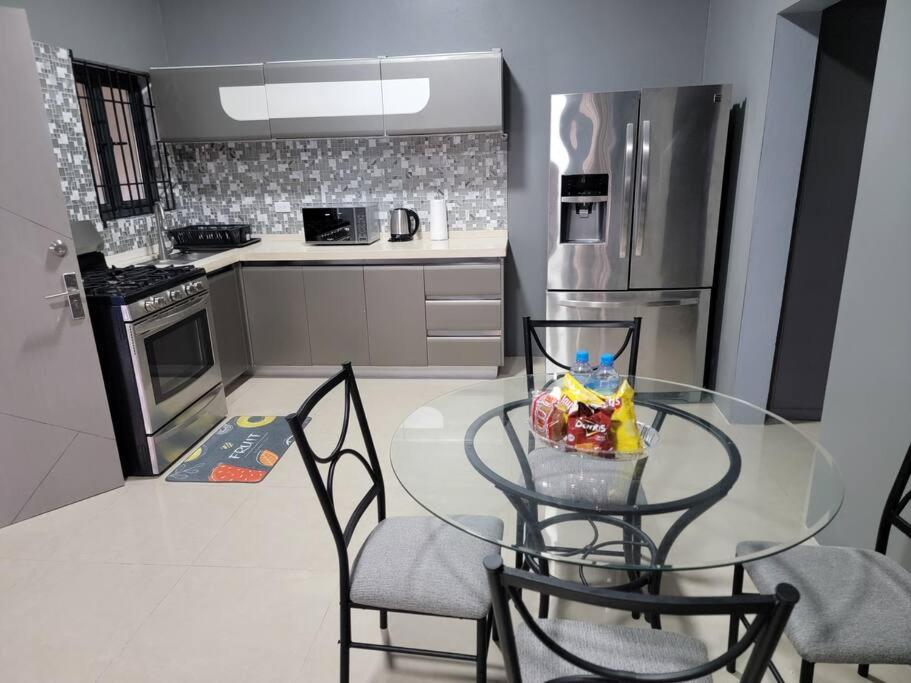 a small kitchen with a glass table and chairs at victory Luxury Suites in Montego Bay