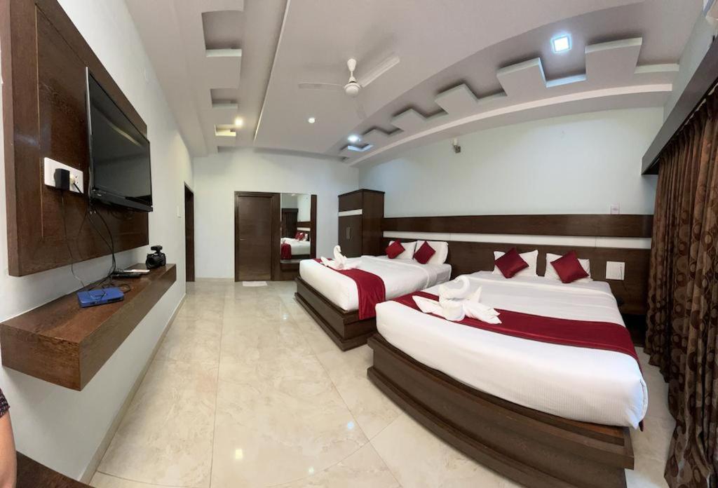 1 dormitorio con 2 camas y TV de pantalla plana en Bandipur Wildlife Resort & Spa, Bandipur, en Bandipūr