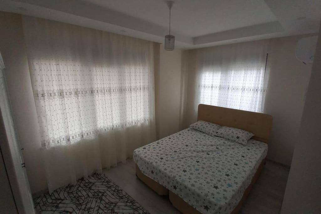 1 dormitorio pequeño con 1 cama y 2 ventanas en Saray park, en Alanya