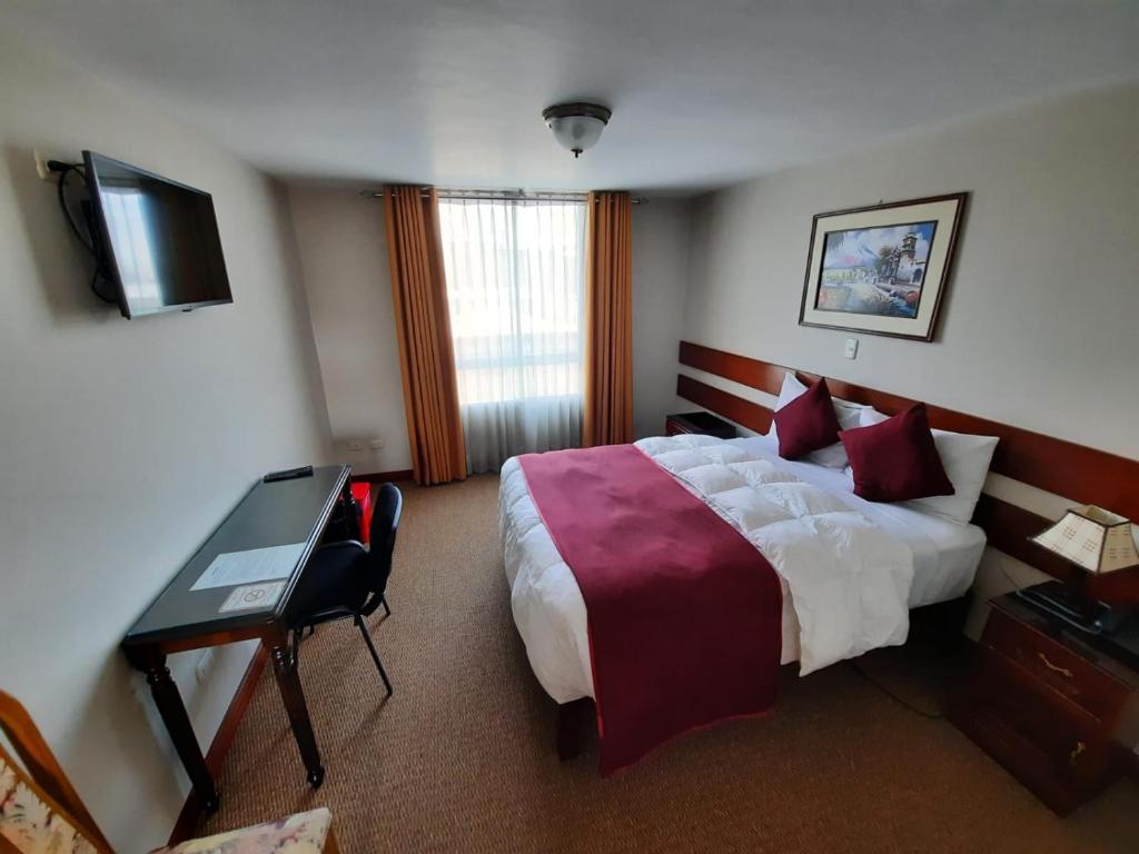 a hotel room with a large bed and a desk at Bella AQP in Arequipa