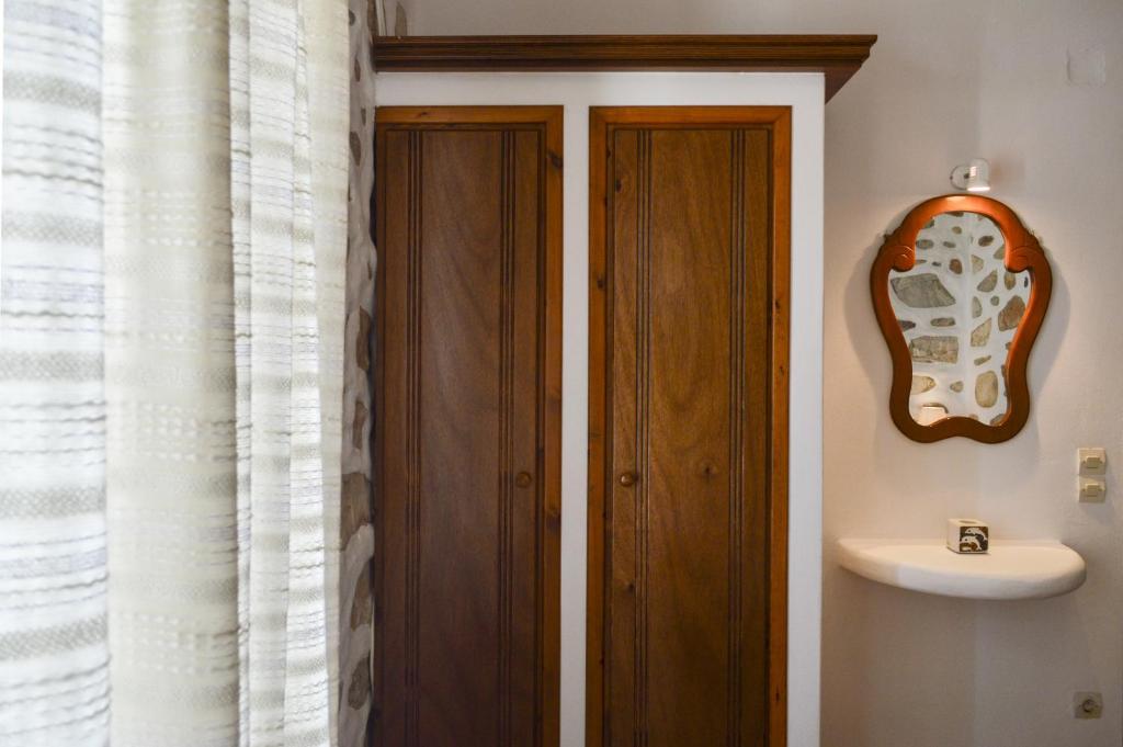 a bathroom with a wooden door and a sink at Villa Peristeri in Agios Georgios