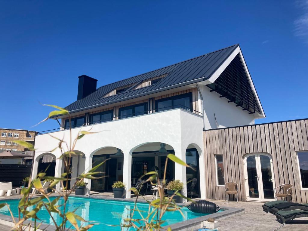 een huis met een zwembad ervoor bij Villa Zandvoort in Zandvoort