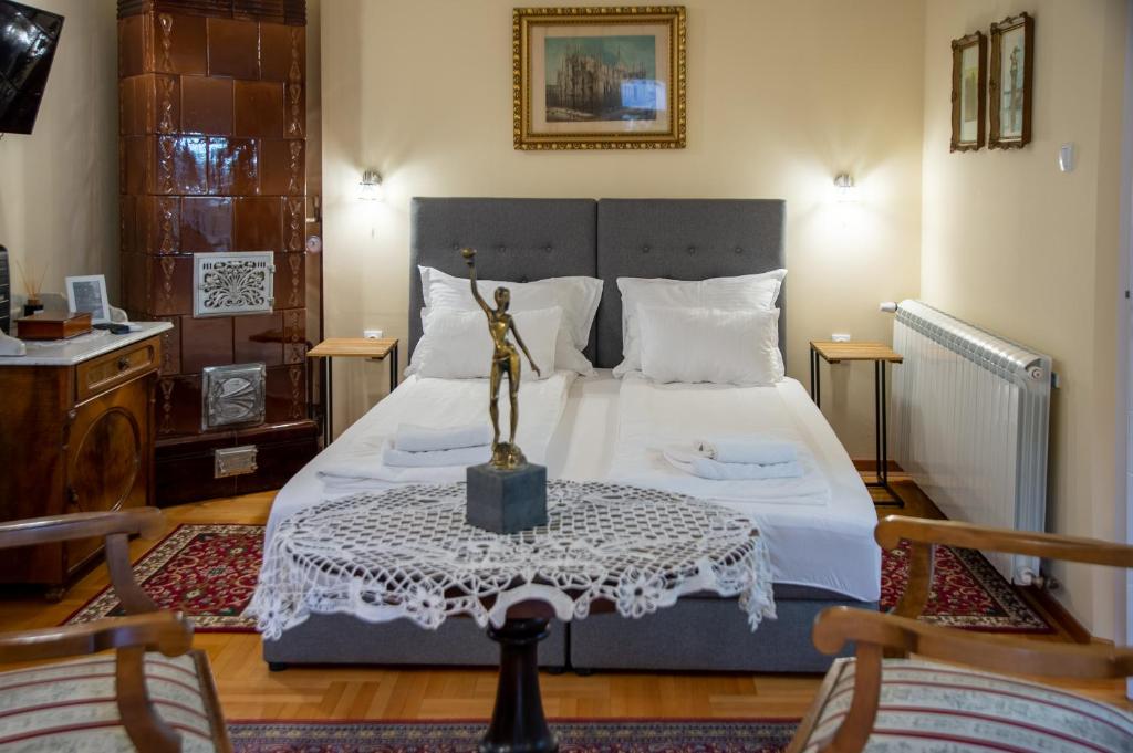 a bedroom with a bed with a statue on a table at Apartman Centar in Sremski Karlovci