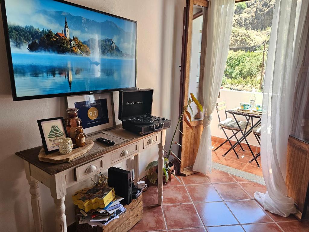 a living room with a tv on top of a table at Casa Fuente Hervera in Vega de San Mateo