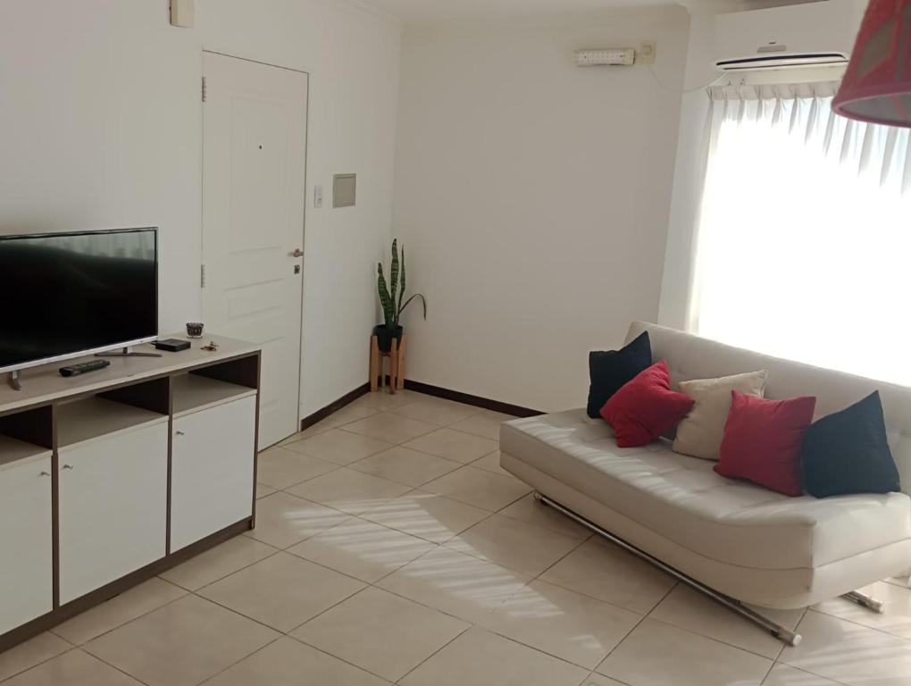 ein Wohnzimmer mit einem Sofa und einem Flachbild-TV in der Unterkunft Apartamento 4 de Enero in Santa Fe