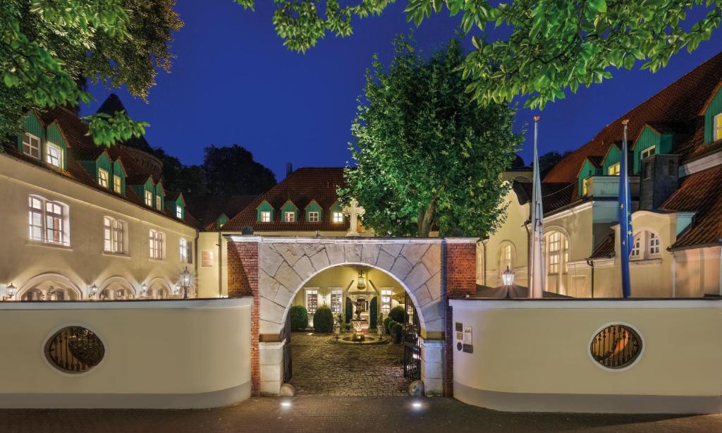 an entrance to a building with an archway at night at Parkhotel Engelsburg - 4 Sterne Superior in Recklinghausen