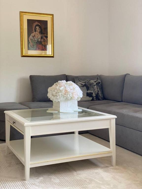 a white coffee table with a vase of flowers on it at Apartment Angelina 