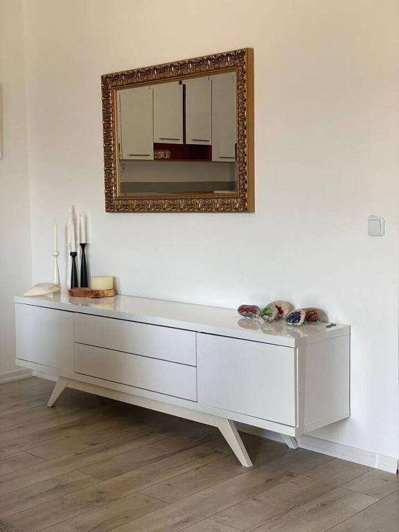 a white dresser with a mirror on a wall at Apartment Angelina 