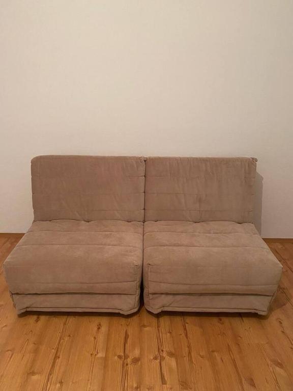 a brown couch sitting on top of a wooden floor at Apartment Angelina 