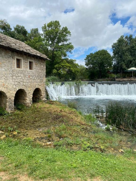 a stone building in front of a waterfall at Apartment Angelina 