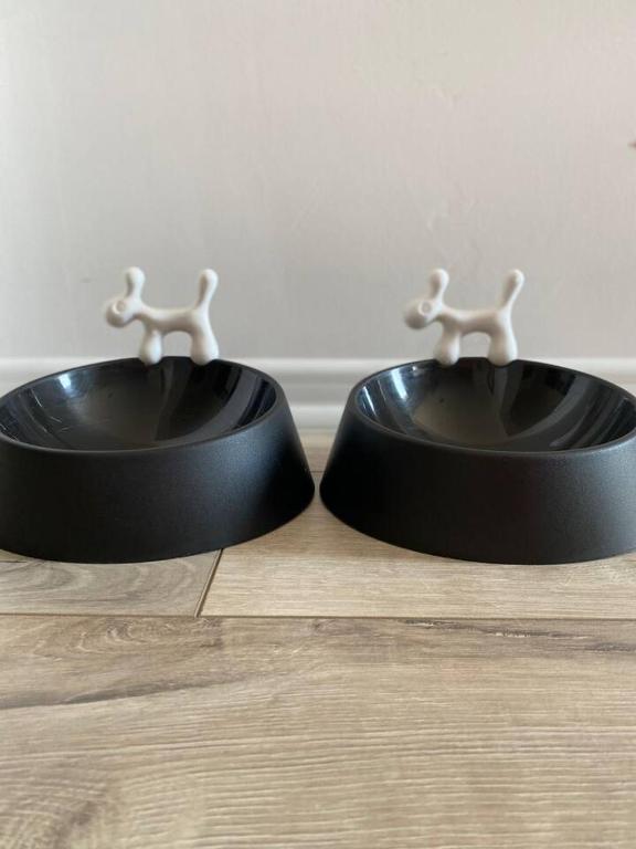 two black dog bowls sitting on a wooden floor at Apartment Angelina 