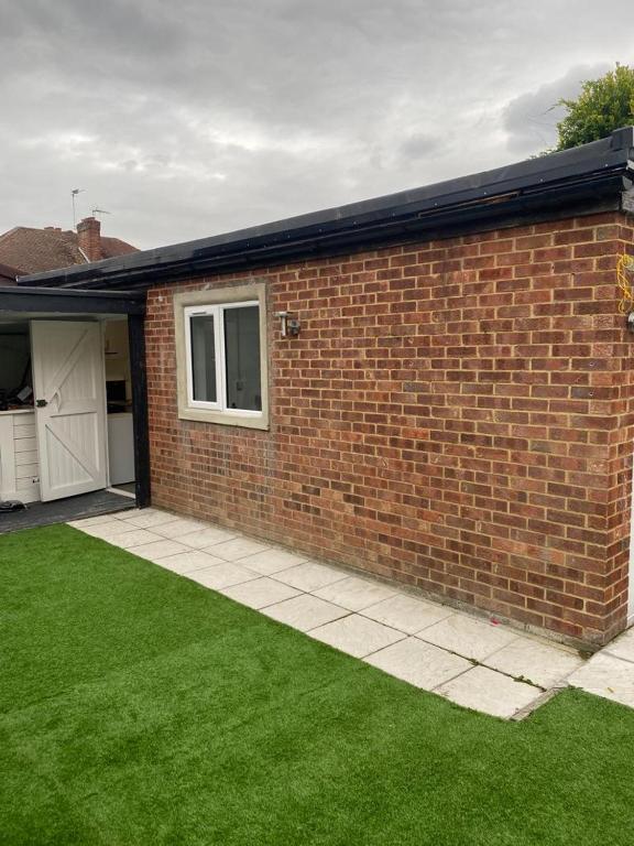 a brick house with a yard with green grass at Oak Lodge in Welling