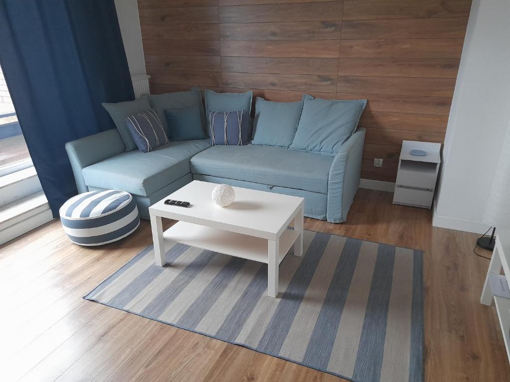Sala de estar con sofá azul y mesa de centro en Żeglarska przystań, en Gdansk