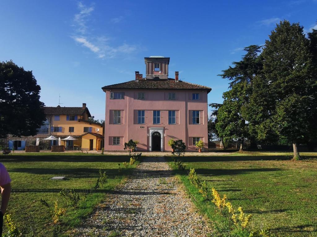 an old pink house with a tower on top of it at Villa San Giorgio Guest House in Serravalle Scrivia