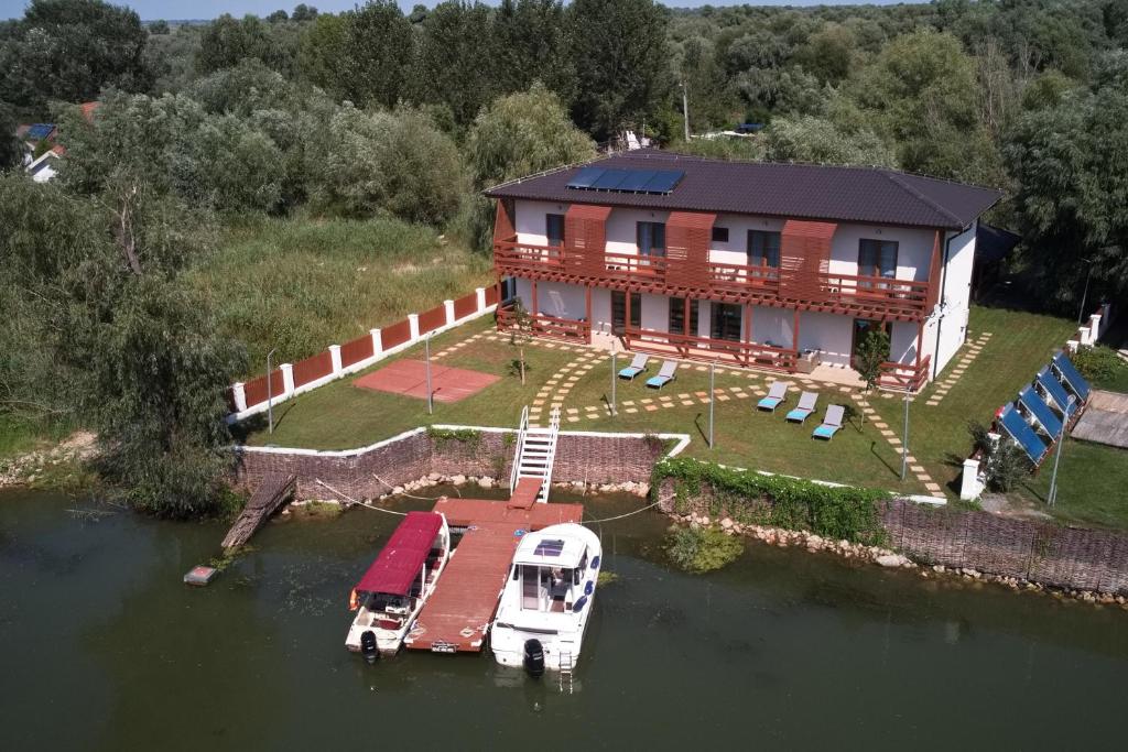 an aerial view of a house with a boat in the water at Eden Uzlina in Uzlina